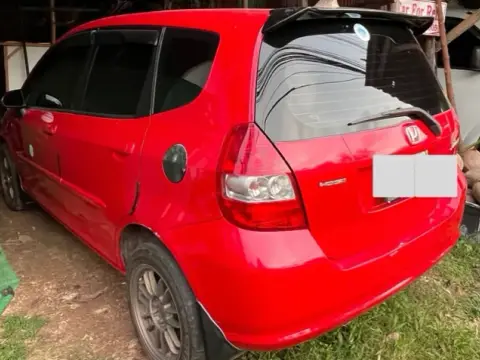 A red compact hatchback parked outside