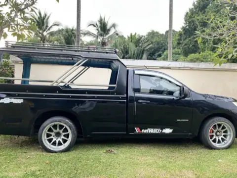 A black pickup taxi with a covered passenger area